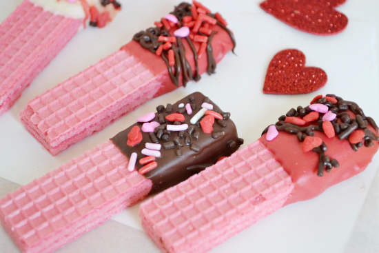 Pink wafer cookies dipped in chocolate and coated with candy sprinkles