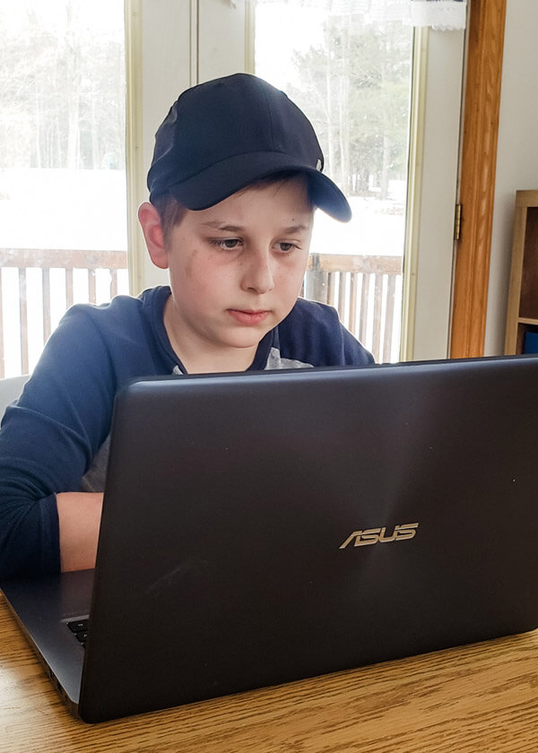 Middle school boy looking intently at laptop screen