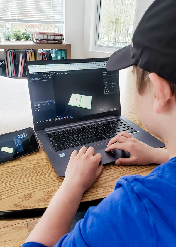 Middle school boy working on laptop to create 3D image