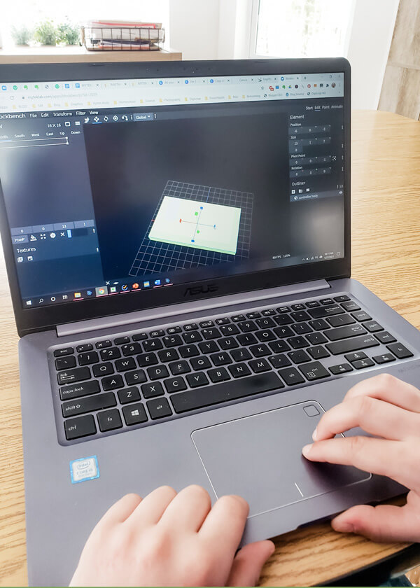 Boy's hands on laptop creating an image in Blockbench