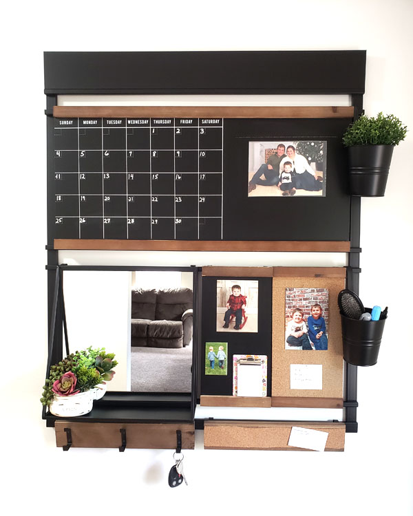 Wall organizer with blackboard, hanging buckets, and succulents on a shelf