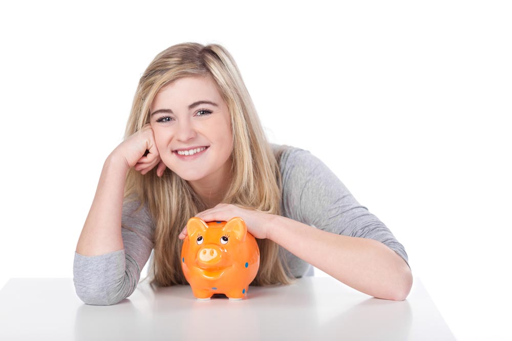 Smiling teenage girl with orange piggy back on white background