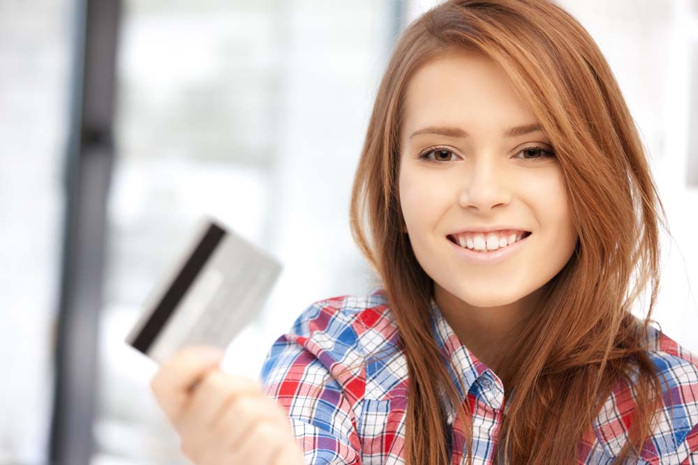Smiling teenage girl holding a credit card