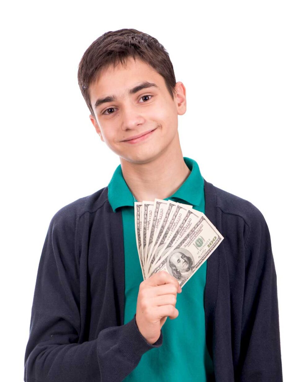 Smiling teenage boy holding a handful of hundred dollar bills on a white background