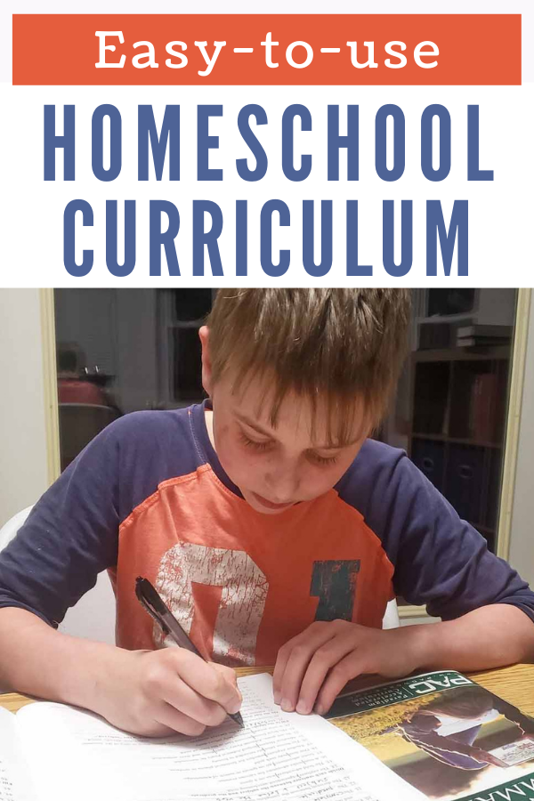 Image of teen boy in orange and blue shirt working in homeschool workbooks