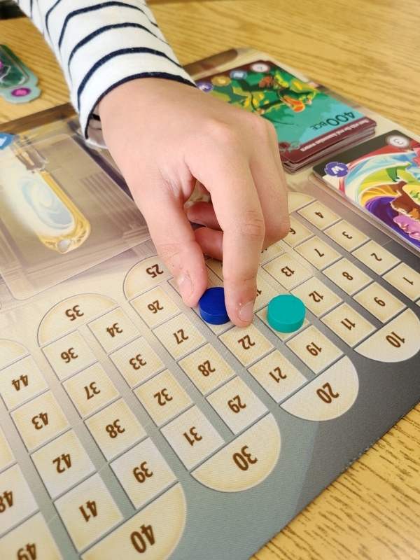 Image of girls hand moving playing pieces on a game board