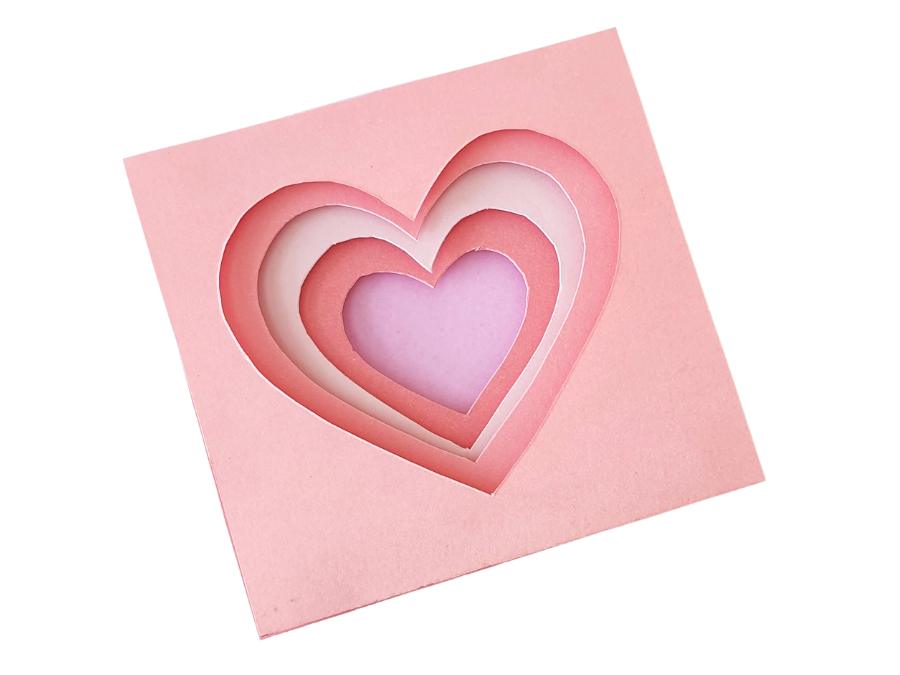 Image of completed 3D cutout heart in shades of pink on a white background.