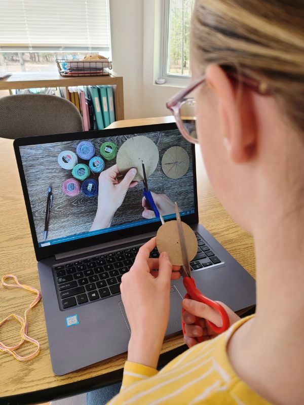 Image of girl sitting in front of laptop displaying a craft tutorial.