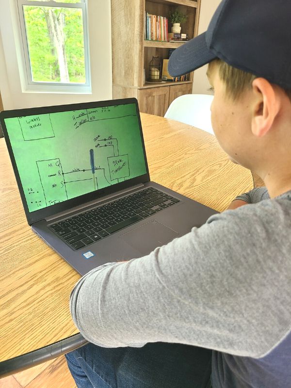 Image of teenage boy watching an online training video for automatic door technicians.