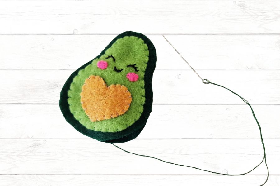 Kids' sewing craft Image of a felt avocado being sewn together to make a stuffie.