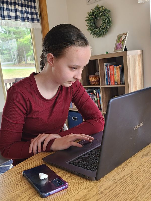 Crypto basics course Image of high school girl using a laptop to complete online lessons.